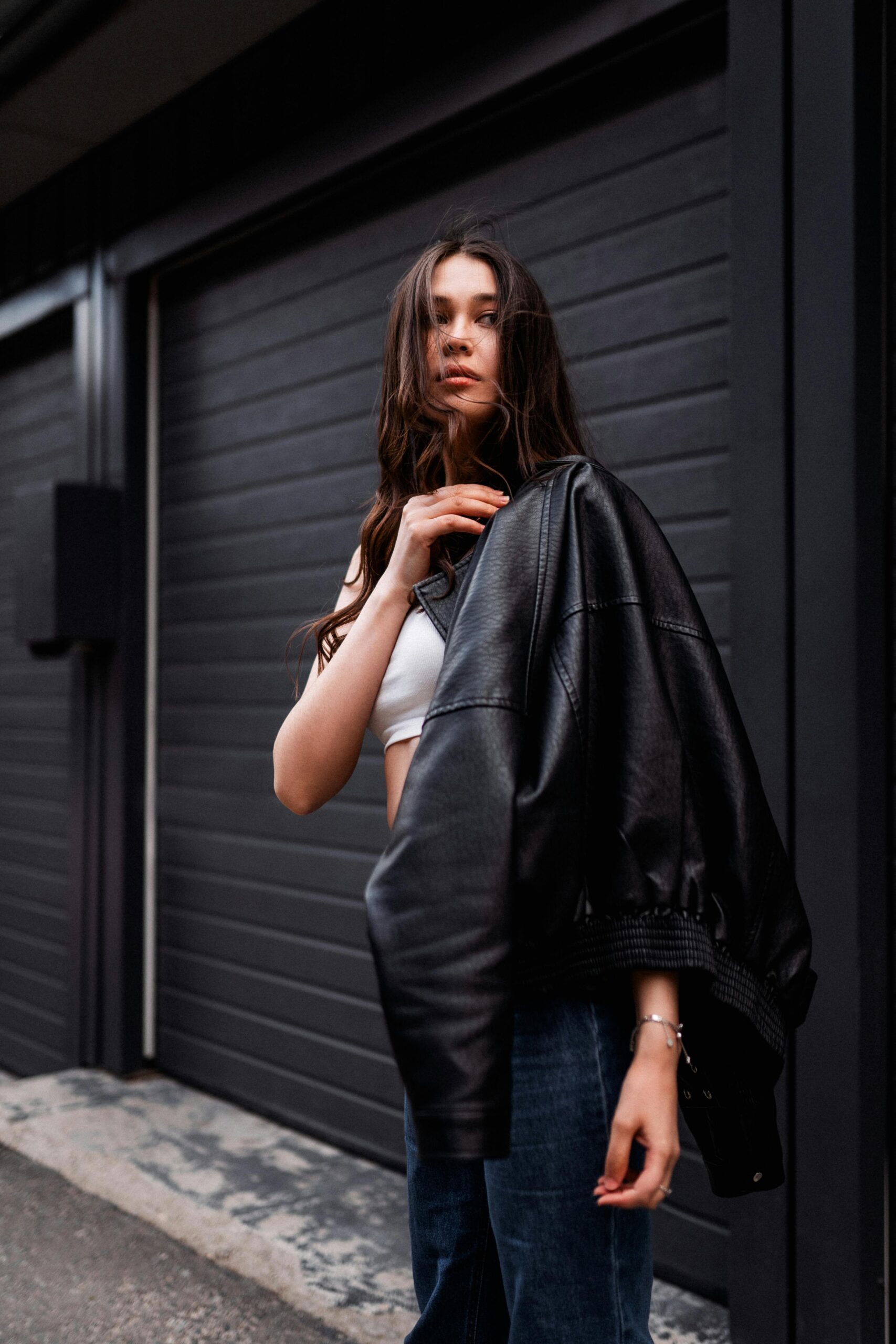 Fashionable young woman posing in Moscow wearing a leather jacket.